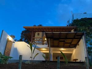 a white house with a wooden pergola at Divina Casa in Itacaré