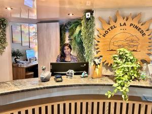a woman standing behind a counter in an office at Hôtel La Pinède in Ajaccio +92 photos