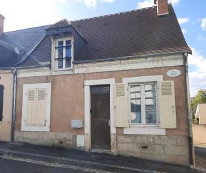 una casa antigua con ventanas blancas y una puerta en Le Logis de la Basse Ville, en Châteauroux