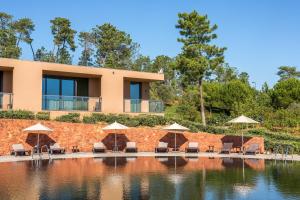 a resort with a pool with chairs and umbrellas at NAU Morgado Golf & Country Club in Portimão