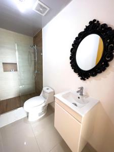 een badkamer met een toilet, een wastafel en een spiegel bij Apartamento en Boca Chica T2 707 in Boca Chica +15 foto's