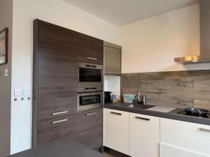 a kitchen with wooden cabinets and a stove top oven at Spacious Family Home and Free Parking in Eindhoven in Eindhoven