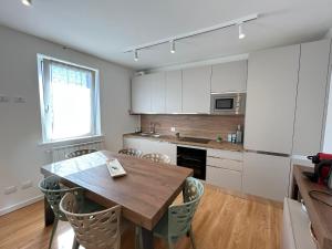 Il comprend une cuisine avec une table en bois et des placards blancs. dans l'établissement Trilo Giudici, à Clusone