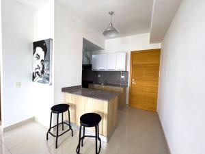een keuken met 2 barkrukken en een aanrecht bij Apartamento en Boca Chica T2 707 in Boca Chica