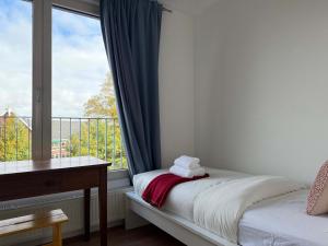 a bedroom with a bed and a window with a balcony at Spacious Family Home and Free Parking in Eindhoven in Eindhoven