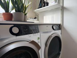 a washing machine in a room with plants on a shelf at Spacious Family Home and Free Parking in Eindhoven in Eindhoven +33 photos