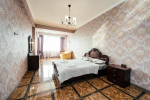 una camera da letto con un letto e un lampadario di Apartment ultra center Sky House a Chişinău