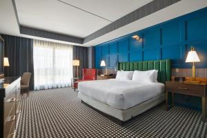 a hotel room with a large bed and blue walls at Oak Grove Racing Gaming & Hotel in Oak Grove