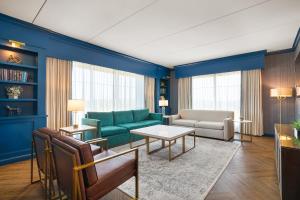 a living room with blue walls and a green couch at Oak Grove Racing Gaming & Hotel in Oak Grove