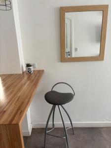 ein Hocker vor einem Schreibtisch mit Spiegel in der Unterkunft Departamento Roca in La Porteña