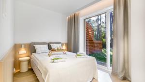ステグナにあるSTEGNA PARK II blisko plaży Apartamenty Piamolaのベッドと大きな窓のある寝室