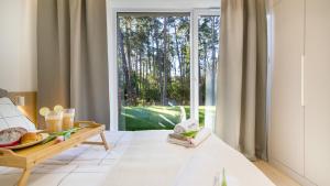 ステグナにあるSTEGNA PARK II blisko plaży Apartamenty Piamolaのベッドと大きな窓のある部屋