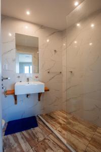 Un baño con lavabo y ducha de cristal. en Complejo Canto del Mar, en Balneario Mar Chiquita 89 fotos más