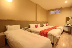 a hotel room with three beds in a room at Tanxiang Resort Hotel Sun Moon Lake Harbour - Sun Moon Lake Pier in Yuchi