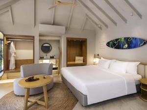 Un dormitorio con una gran cama blanca y una mesa. en Mercure Rayong Lomtalay Villas & Resort, en Mae Pim 116 fotos más
