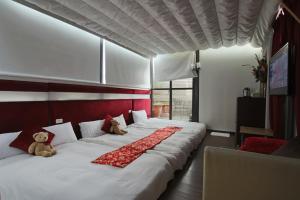 una cama grande con dos ositos de peluche sentados en ella en Tanxiang Resort Hotel Sun Moon Lake Harbour - Sun Moon Lake Pier, en Yuchi