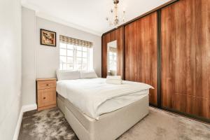 a bedroom with a large bed and a wooden wall at Chic 3Bed House & Garden Near Shelford High Street in Trumpington
