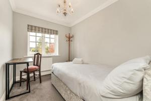 a bedroom with a bed and a desk and a window at Chic 3Bed House & Garden Near Shelford High Street in Trumpington