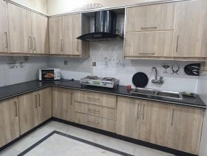 a kitchen with wooden cabinets and a sink at Guest House & Apartments Johar Town near Emporium & Expo in Lahore