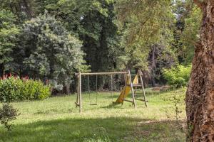 a swing set in a field with a tree at Casa Noel in Linguizzetta