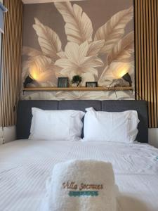 a bedroom with a large bed with white pillows at Villa Sokrates in Nea Vrasna