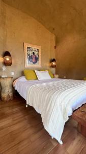 1 cama blanca grande en una habitación con 2 luces en Casa Redonda, en Golondrinas