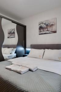a bedroom with a large bed with white pillows at Apartman Nada de lux in Vrnjačka Banja