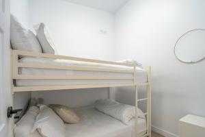 un lit superposé blanc avec des oreillers et un miroir dans l'établissement Chalet à louer au bord d'un lac avec spa, à La Baie