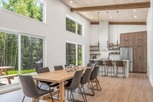 - une salle à manger et une cuisine avec une table et des chaises en bois dans l'établissement Chalet à louer au bord d'un lac avec spa, à La Baie