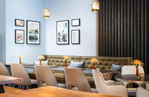 ザルツブルクにあるLeonardo Hotel Salzburg City Centerのレストラン内のテーブルと椅子のあるダイニングルーム