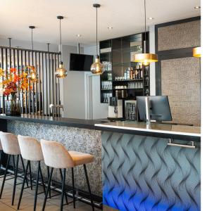 ザルツブルクにあるLeonardo Hotel Salzburg City Centerのキッチン(スツール付きのバー付)
