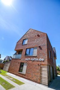 een bakstenen gebouw met de woorden syphilis horizons erop bij Sylt Lofts in Westerland