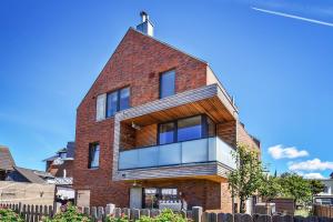 a red brick house with a large window at Sylt Lofts in Westerland