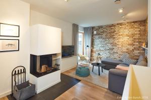 een woonkamer met een bank en een open haard bij Sylt Lofts in Westerland