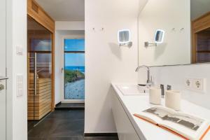 een badkamer met een wastafel en een spiegel bij Sylt Lofts in Westerland +73 foto's