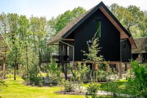 a black house with a gambrel roof at Natuur Villa met Hottub & Sauna | 4 personen - Resort Valley in Wekerom