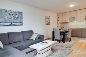 a living room with a couch and a table at Apartman Nada de lux in Vrnjačka Banja