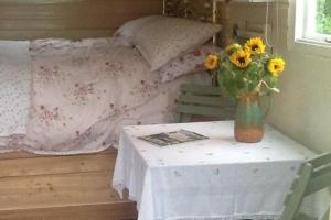 a table with a vase of sunflowers on top of a bed at 1Bed Cabin Sleeps 2- Parking Fireplace Garden Pets in Lizard
