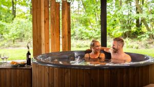 WekeromにあるNatuur Villa met Hottub | 2 personen - Resort Valleyの温水浴槽にいる男性と女性 +18枚の写真