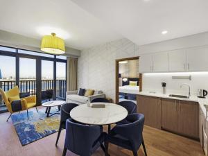 a kitchen and living room with a table and chairs at Aparthotel Adagio Dubai Deira in Dubai +83 photos