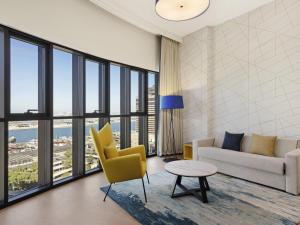 un salon avec un canapé, des chaises et une table dans l'établissement Aparthotel Adagio Dubai Deira, à Dubaï 83 autres photos