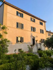 a large yellow building with windows and bushes at Poggio Bernone - Massa Marittima in Prata +57 photos