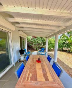 a large wooden table and chairs on a patio at Villa KAZ, 2 chambres avec salle de bain privée in Cul de Sac