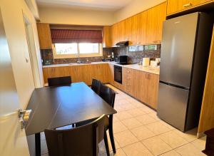 a kitchen with a table and a stainless steel refrigerator at Family House in Limassol