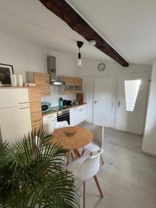 a kitchen with a wooden table and white chairs at Wohnung nähe Phantasialand und Köln in Hürth
