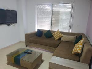 a living room with a brown couch and a coffee table at S2 lux jardin carthage in Tunis