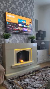 a living room with a fireplace with a flat screen tv at House4 holiday in Liverpool