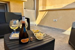 a bottle of wine and a glass on a table at Casa Lucid'amare Relaxation in Isola delle Femmine