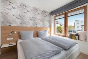 a bedroom with a bed with birds on the wall at Sylt Lofts in Westerland (Sylt)