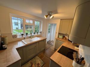 a large kitchen with a sink and a window at Delightful 3-bedroom Cottage, Brockenhurst in Brockenhurst